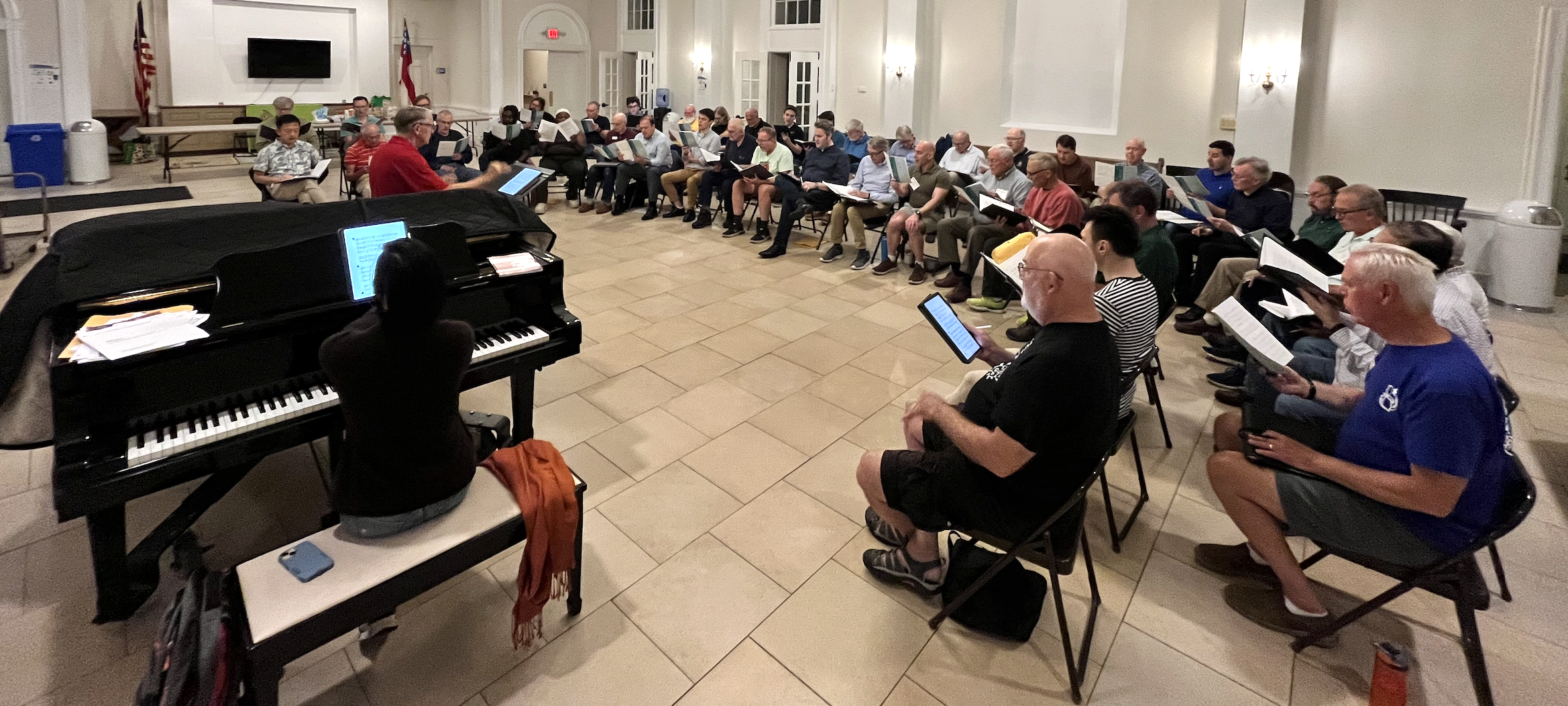 Photos of a few singers rehearsing, holding music, with a description of Summer Sing.